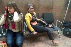 Two women sit in the airport in Brussels after the Tuesday morning explosions. The blasts hit near the departure gates, collapsing ceiling panels and shattering glass windows; Belgian media said 11 people were killed.